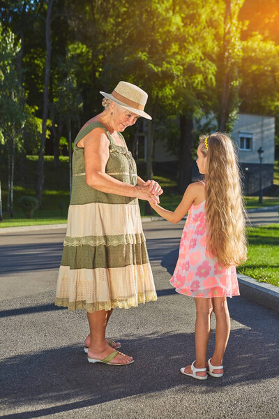Старшая женщина улыбается внучке
.