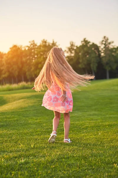 Liten flicka Dans, gröna gräs. — Stockfoto