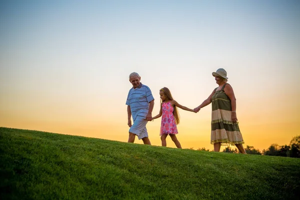 Niña y abuelos, cielo del atardecer . —  Fotos de Stock