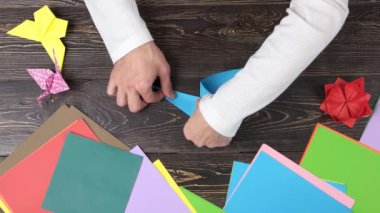 Mavi origami turna şekillendirme eller.