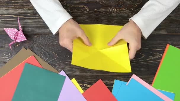 Mann macht gelben Papierschmetterling. — Stockvideo