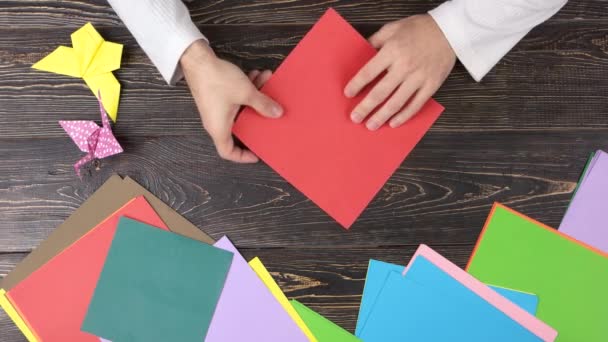 Male hands folding red paper sheet. — Stock Video