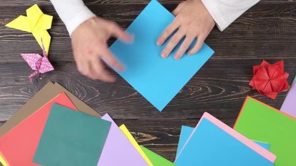 mannelijke handen vouwen blauw papier — stockvideo © denisfilm