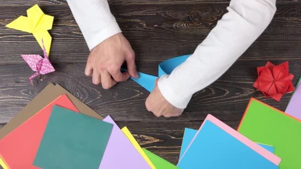 Handen vormen blauwe origami kraan. — Stockvideo