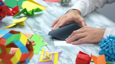 Siyah origami swan yapan erkek.