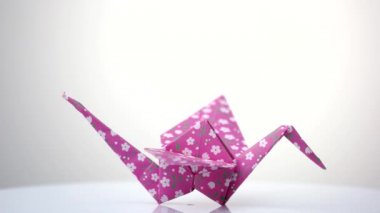 Beyaz üzerine pembe desenli orizuru heykelcik.