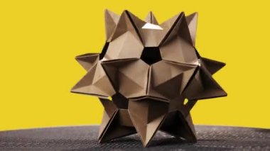 Origami kozmik şekil Sarı zemin üzerine.