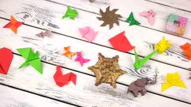 Rustik ahşap arka plan üzerinde origami nesneleri kümesi.