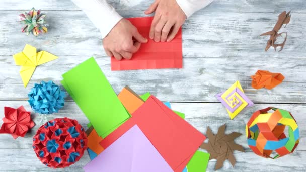 Männliche Person kreiert Origami-Objekt. — Stockvideo