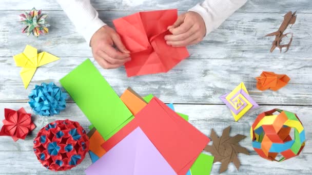 Person making origami flower, top view. — Stock Video