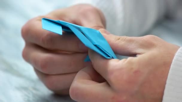 Close up male hands folding origami figure. — Stock Video