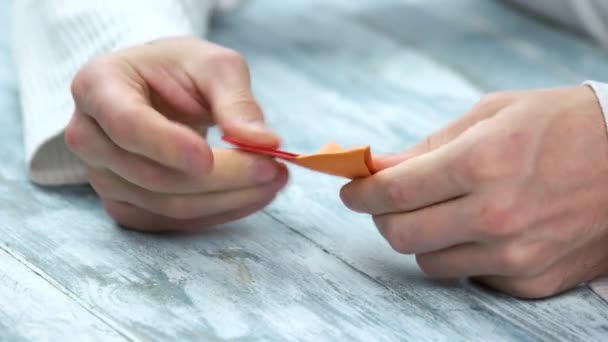 Руки делают четыре остроконечных оригами сюрикен . — стоковое видео