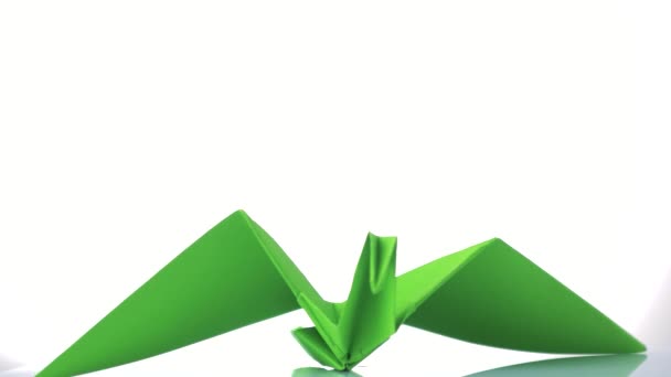 Green paper crane on white background. — Stock Video