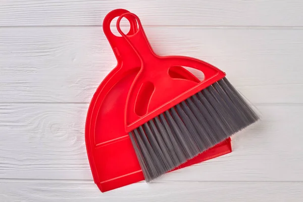 Red dustpan and brush on wooden background. — Stock Photo, Image