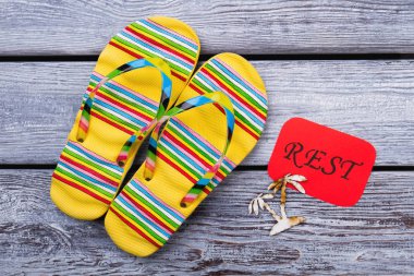 Sarı parmak arası terlik sandalet, düz yatıyordu.