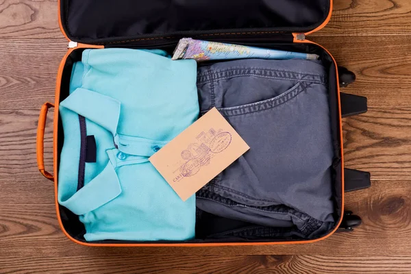 Resväskan packad med prydligt vikta kläder. — Stockfoto