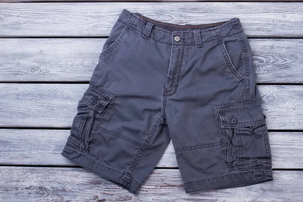 Pantalones cortos masculinos negros en madera . — Foto de Stock