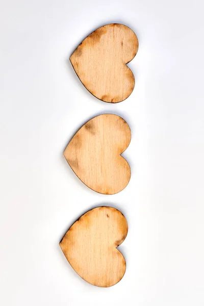 Fila de três corações de madeira compensada, vista superior . — Fotografia de Stock