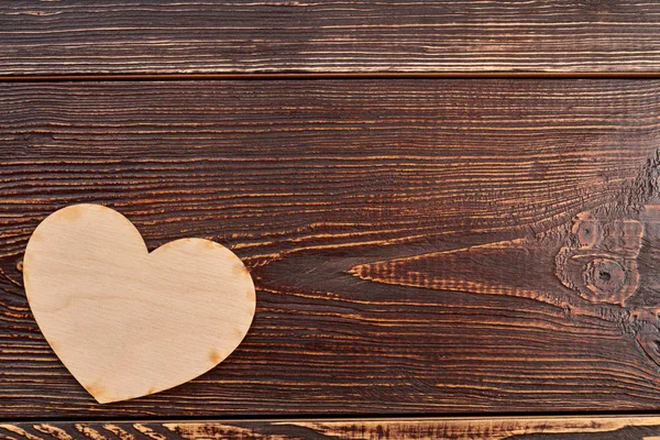 Corazón de madera sobre fondo de textura oscura . — Foto de Stock