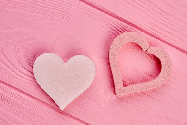 Twee vormen van hart op roze hout. — Stockfoto