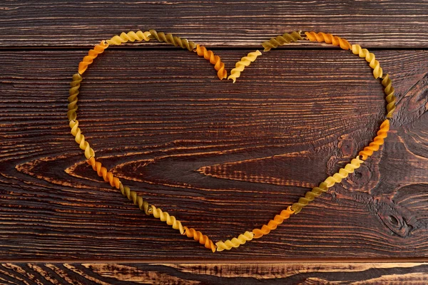 Heart frame from colorful fusilli pasta.
