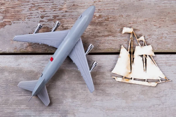 Samolot plastikowe zabawki i płaskie drewniany statek. — Zdjęcie stockowe