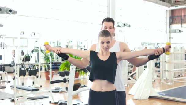 Flicka som träning i gymmet med personlig tränare. — Stockvideo