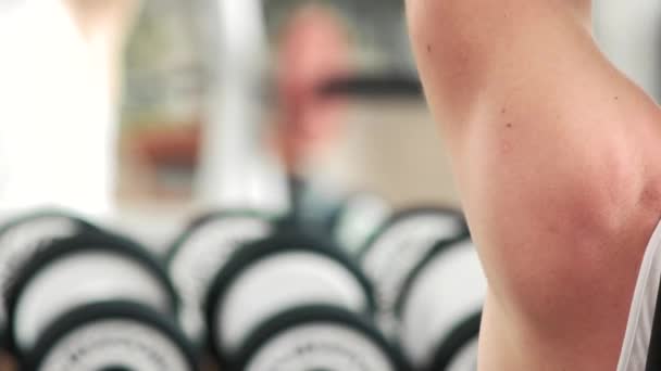 Close-up de um jovem musculoso levantando pesos . — Vídeo de Stock