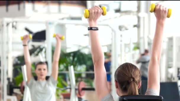 Woman flexing hands with dumbbells. — Stock Video