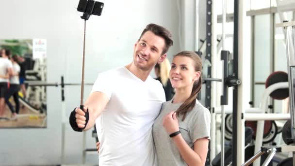 Χαρούμενο ζευγάρι λαμβάνοντας αυτοπορτρέτα στο γυμναστήριο. — Αρχείο Βίντεο