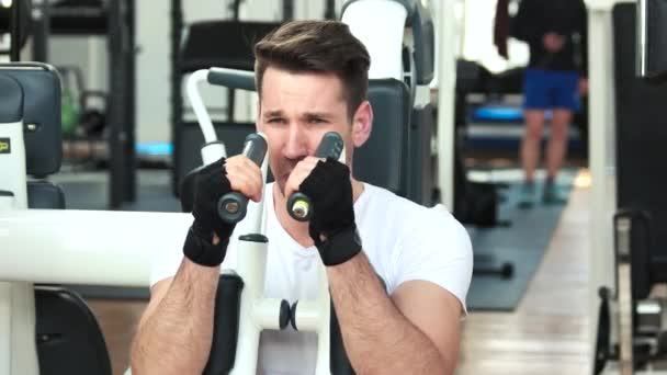 Chico guapo de camisa blanca entrenando en el gimnasio . — Vídeos de Stock