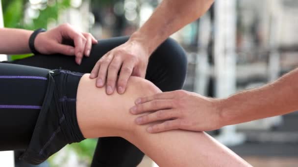 Mãos masculinas massageando joelho feminino. — Vídeo de Stock