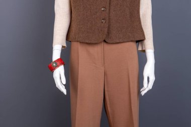 Kadın kahverengi pantolon ve yelek.