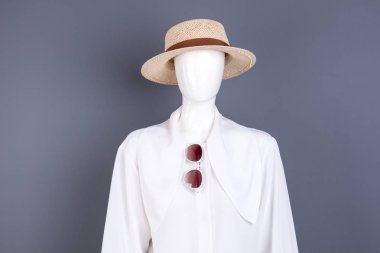 Şapka, beyaz bluz ve güneş gözlüğü.