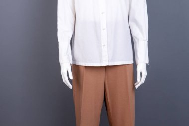 Manken kadın gömlek ve pantolon giymiş.