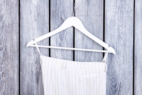 Vrouwelijke kleding op hanger, houten achtergrond. — Stockfoto