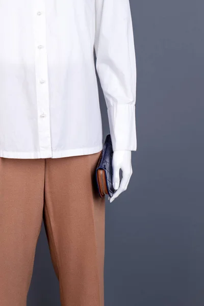 Mannequin with white shirt and purse.