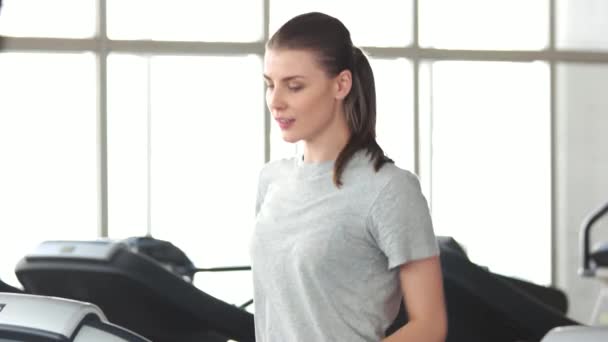 Mujer alegre haciendo ejercicio cardiovascular en el gimnasio . — Vídeos de Stock