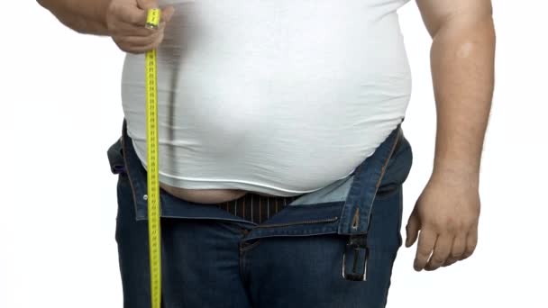 Gordo está medindo sua barriga usando fita métrica . — Vídeo de Stock