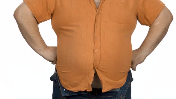 Hombre gordo en camisa naranja apretada sobre fondo blanco . — Vídeos de Stock