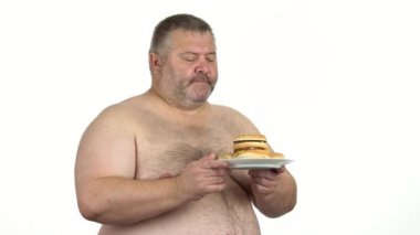 Elinde hamburger tabağı olan çıplak şişman bir adam..