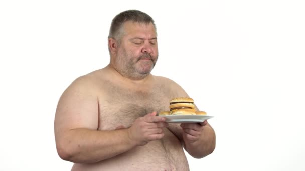 Nackter dicker Mann hält Teller mit Burgern. — Stockvideo