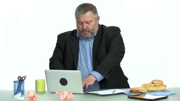 Бизнесмен ест фаст-фуд во время работы в офисе . — стоковое видео