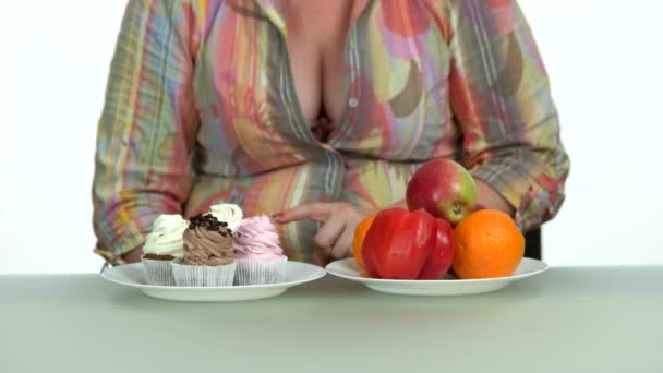 Woman deciding between healthy and unhealthy food. — Stock Video