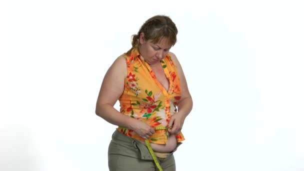 Υπέρβαρη γυναίκα που μετράει τη μέση της με μέτρο ταινίας. — Αρχείο Βίντεο