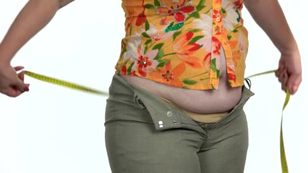Mujer con sobrepeso midiendo su vientre gordo. — Vídeo de stock