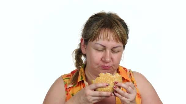 Mulher encantada comer hambúrguer no fundo branco . — Vídeo de Stock