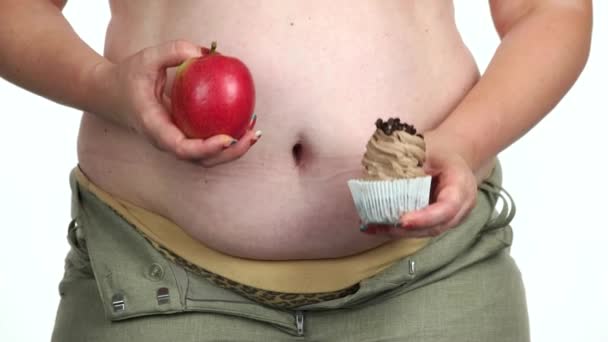 Mujer gorda sosteniendo pastel y una manzana . — Vídeos de Stock