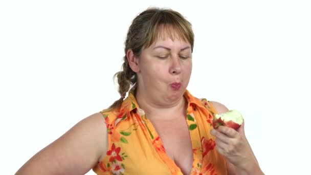 Mujer gorda comiendo una manzana sobre fondo blanco . — Vídeos de Stock