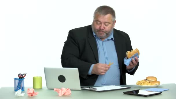 Buitensporige kantoormedewerker met een ongezonde snack. — Stockvideo